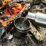 Tasse en titane 750ml qui chauffe de l'eau sur le feu de camp